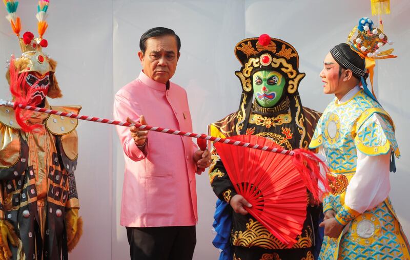 Thai Prime Minister Prayut Chan-o-cha interacts with performers in Chinese opera costumes before a weekly cabinet meeting at the Government House in Bangkok. EPA