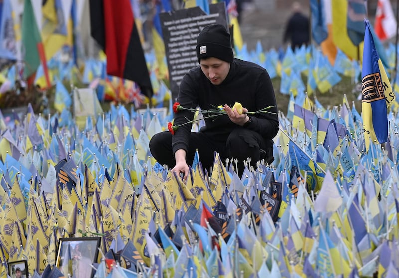 A man pays tribute at a makeshift memorial for fallen Ukrainian soldiers, at the Independence Square in Kyiv. AFP