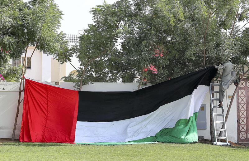 DUBAI , UNITED ARAB EMIRATES , NOV 1   – 2017  :- One of the worker decorating villa in Jumeirah with UAE flag for the Flag Day celebrations which is happening tomorrow in Dubai. (Pawan Singh / The National) 