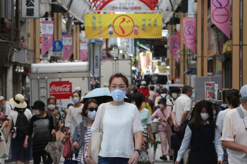 People wearing face masks to protect against the spread of the new coronavirus walk in Yokohama, near Tokyo. AP Photo
