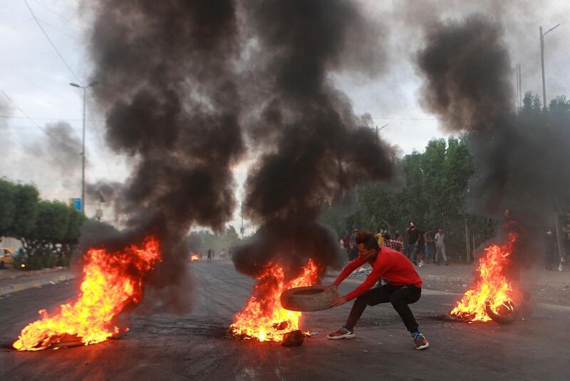 Anti-government protesters set fires and close a street during a demonstration in Baghdad, Iraq.  AP Photo