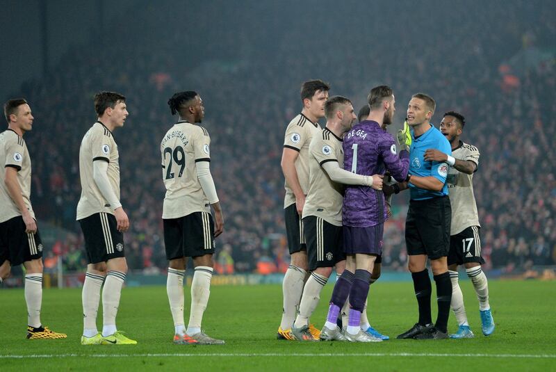 Manchester United's players surround referee Craig Pawson before Roberto Firmino's goal is disallowed. EPA