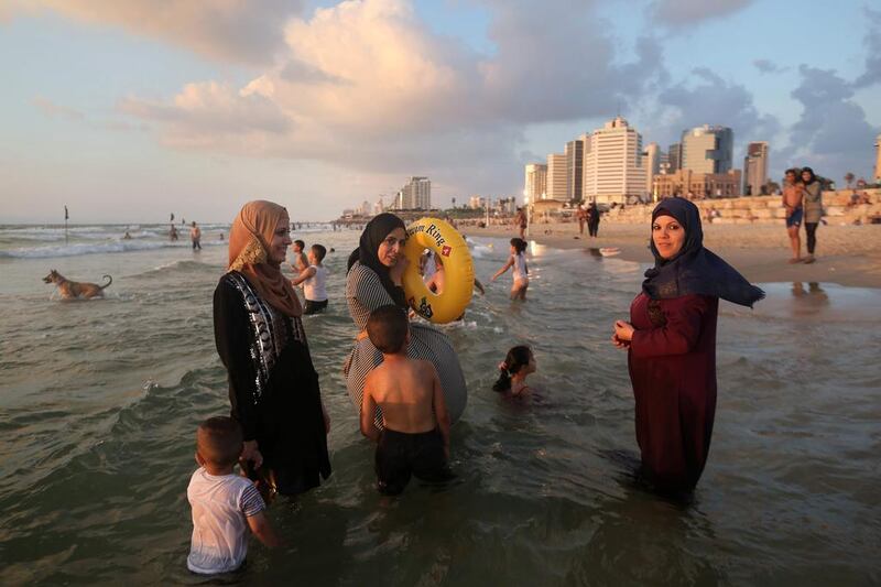 Palestinian women are seen on the beach during the Eid al-Adha holiday.  Thousands of Palestinians from the West Bank swam at beaches in and around the Israeli commercial capital Tel Aviv, after being granted permits to visit during the Eid al-Adha holiday.  Menahem Kahana / AFP
