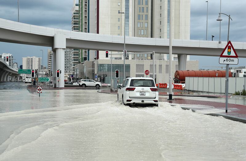 A car drives through a waterlogged roads in Dubai. Pawan Singh / The National