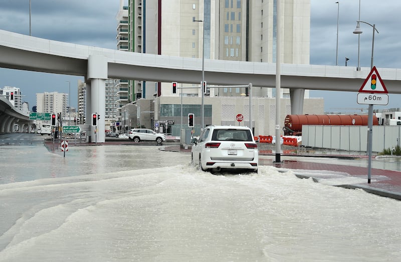 A car drives through a waterlogged roads in Dubai. Pawan Singh / The National