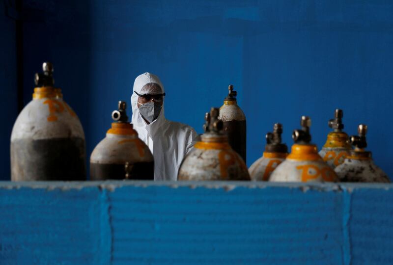 A medical worker stands next to an oxygen cylinder at the Yatharth Hospital in Noida, on the outskirts of New Delhi, India. REUTERS