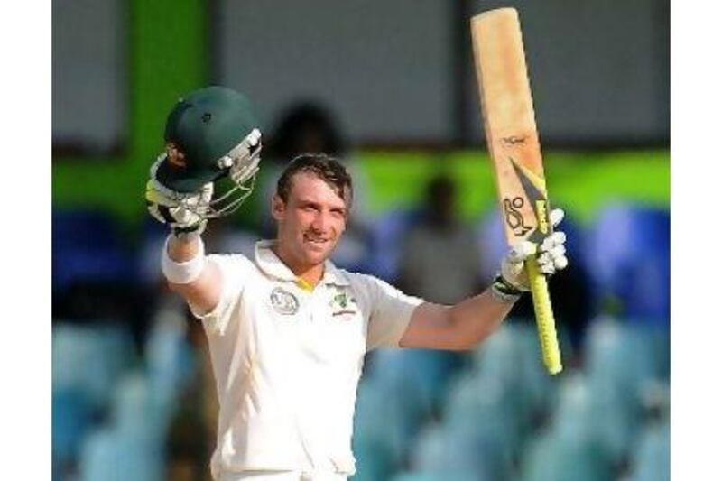 Phillip Hughes raises his bat to celebrate a third Test hundred, which he scored at a fast clip with one six and 16 fours.