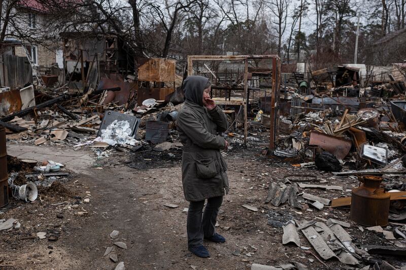 Olia, 53, stands next to destroyed constructions in her courtyard in Bucha on Tuesday. (Photo by Alexey Furman / Getty Images)