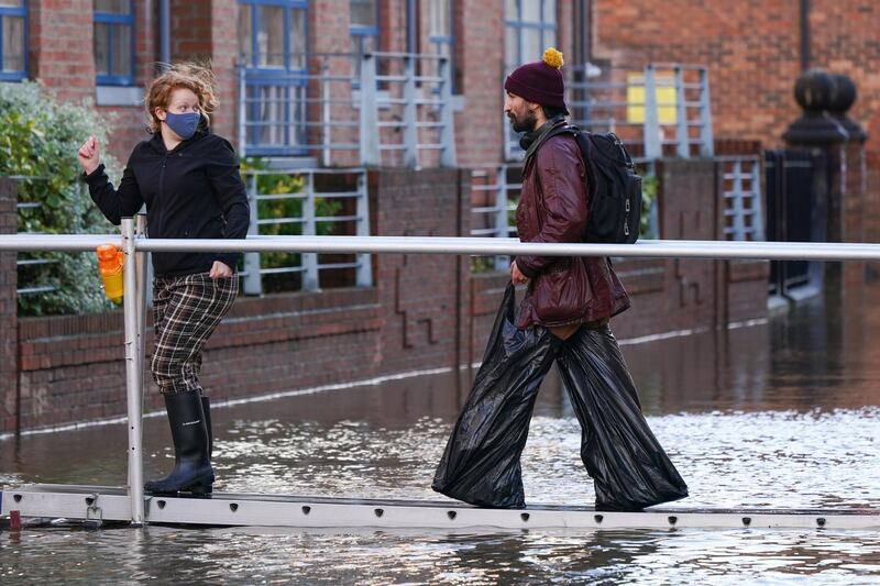 A man wears improvised waders as he walks through flood water after the River Ouse in York flooded. Getty Images