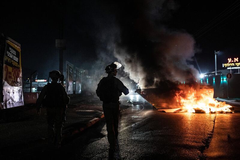 Israeli police patrol during clashes between Arabs, police and Jews, in the mixed town of Lod. As rockets from Gaza streaked overhead, Arabs and Jews fought each other on the streets below. Rioters torched vehicles, a restaurant and a synagogue. AP