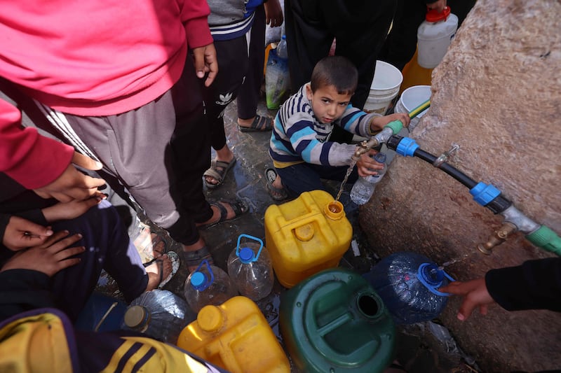 Palestinian children fetch water in Rafah, in the southern Gaza Strip, AFP