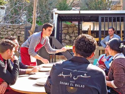 Happier times: Qais Malhas hands out meals to staff as they enjoy a break at Shams El Balad