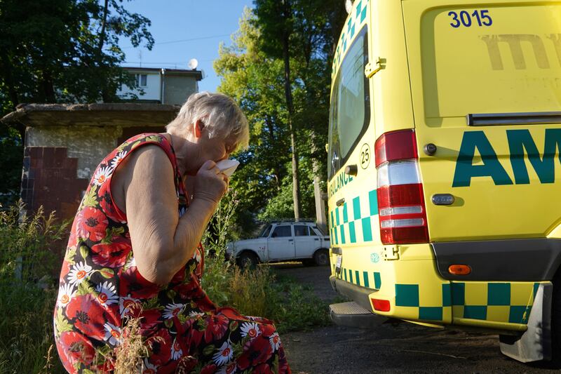 A woman cries after the body of her husband, who was killed in the yard of an apartment building during shelling, was loaded into an ambulance in Kharkiv, Ukraine. AP