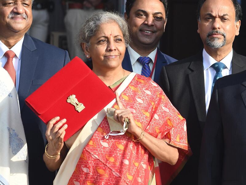 epa08979054 Indian Finance Minister Nirmala Sitharaman holds a folder containing Union Budget 2021 documents outside the Ministry of Finance in New Delhi, India, 01 February 2021. The Union Budget 2021 will be presented in the parliament by the country's finance minister Sitharaman.  EPA/STR