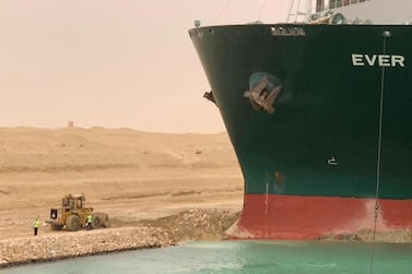 Workers are seen next to a container ship which was hit by strong wind and ran aground in Suez Canal, Egypt March 24, 2021. Suez Canal Authority/Handout via REUTERS ATTENTION EDITORS - THIS IMAGE WAS PROVIDED BY A THIRD PARTY. NO RESALES. NO ARCHIVES TPX IMAGES OF THE DAY