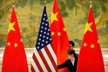 Chinese staffers adjust US and Chinese flags before the opening session of trade negotiations in Beijing last year. Reuters