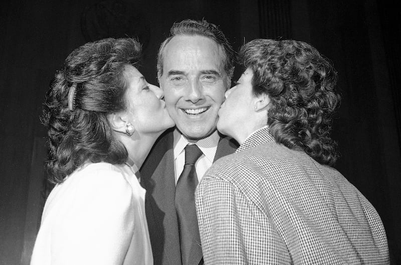 Newly elected Senate majority leader Dole is kissed by his wife, Transport Secretary Elizabeth Dole, and his daughter, Robin, on Capitol Hill in Washington, in November 1984. AP