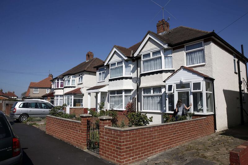 A member of the media stands outside the front door of a house registered to Nav Sarao Futures Ltd, a trading company operated by Navinder Singh Sarao, in Hounslow, west of London on April 22, 2015. Adrian Dennis / AFP

