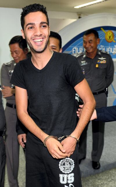 Hamza Bendelladj of Algeria (C), a suspect on the US Federal Bureau of Investigation's top ten wanted list for allegedly hacking private accounts in 217 banks and financial companies worldwide, is escorted by Thai police officers during a press conference at the Immigration Police Bureau in Bangkok on January 7, 2013. Bendelladj, who graduated in computer sciences from a college in Algeria in 2008, has allegedly hacked private accounts in 217 banks and financial companies worldwide, amassing "huge amounts" in illicit earnings, the police commissioner told a press conference.  AFP PHOTO / PORNCHAI KITTIWONGSAKUL (Photo by PORNCHAI KITTIWONGSAKUL / AFP)