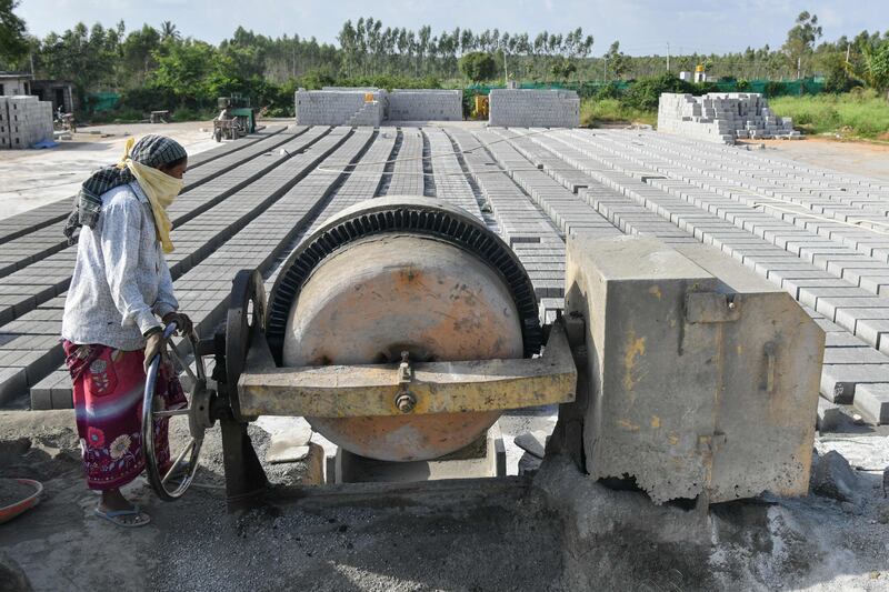 A concrete mixing machine at a cement brick factory in Bangalore, India. Sectors including cement and steel are facing the most complex decarbonisation challenges, a WEF report says. AFP