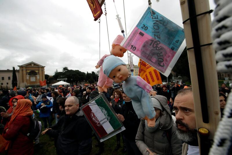 Hanged dolls are shown during a rally to protest mandatory vaccines, in Rome, Saturday, Feb. 24, 2018. Thousands of police have been deployed for protests in Rome, Milan and other Italian cities tasked with preventing clashes during an election campaign that has increasingly been marked by violence. (AP Photo/Alessandra Tarantino)