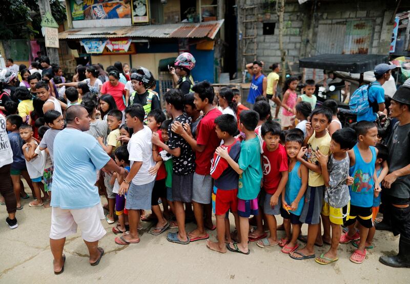 Filipino children queue during a relief operation.  EPA