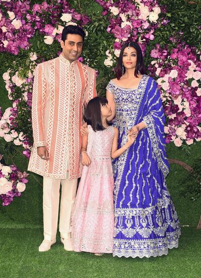 Bollywood actor Abhishek Bachchan (L) poses for photographs along with his wife and actress and model Aishwarya Rai Bachchan (R), and their daughter (C), as they arrive to attend the wedding ceremony of Akash Ambani, son of Indian businessman Mukesh Ambani, in Mumbai on March 9, 2019. / AFP / SUJIT JAISWAL
