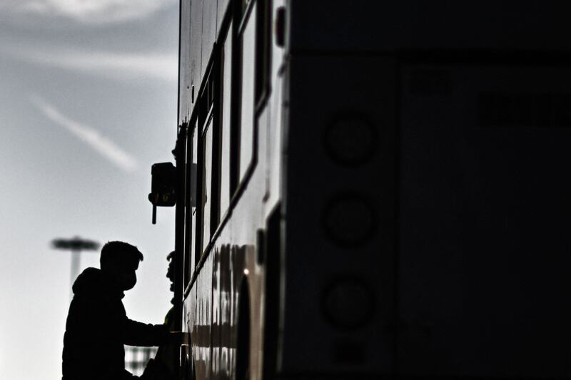 A migrant found at sea while attempting to cross the English Channel boards a bus to be taken for processing in Dover. AFP