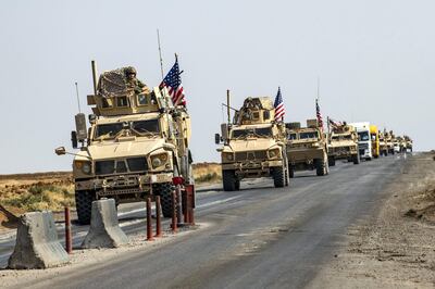A convoy of US military vehicles, arriving from northern Iraq, drives along a road in the countryside of Syria's northeastern city of Qamishli on October 26, 2019. (Photo by Delil SOULEIMAN / AFP)