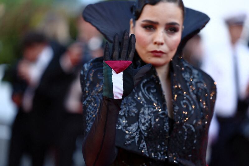 Un Certain Regard jury member Asmae El Moudir reveals the Palestinian flag on the palm of her glove at the Cannes Film Festival closing ceremony. Reuters