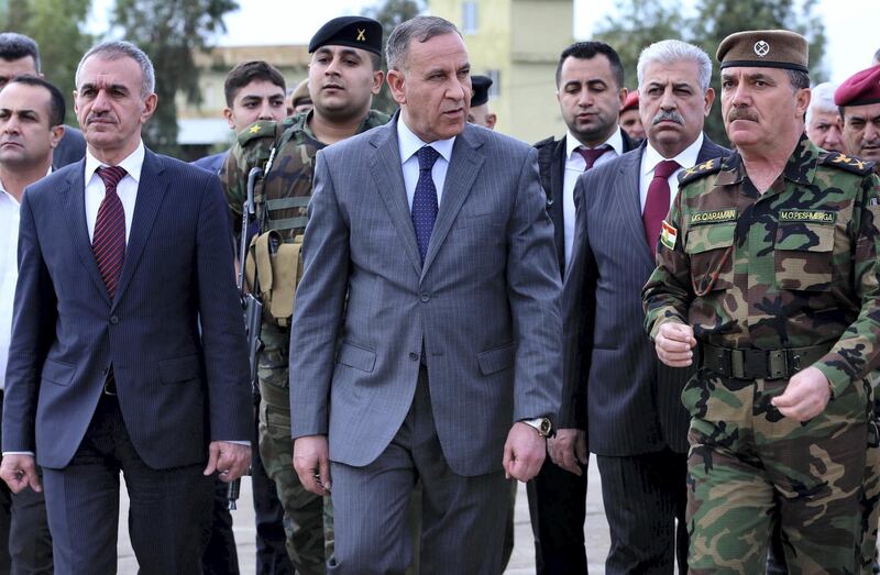 Iraqi Defence minister Khalid al-Obaidi (C) and Minister of Peshmerga Affairs Mustafa Said Qadir (L) visit a training camp for Kurdish peshmerga troops on November 3, 2014 in Arbil, the capital of the autonomous Kurdish region of northern Iraq. Kurdish peshmerga forces streamed across the Syrian border from Turkey on October 31 to bolster defenders in the key border town of Kobane which is under assault by Islamic State group jihadists.  AFP PHOTO / SAFIN HAMED / AFP PHOTO / SAFIN HAMED