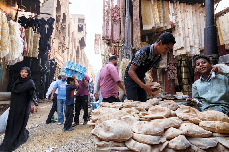 E5356T Bazaar street scene with child selling bread. Islamic Cairo, Egypt