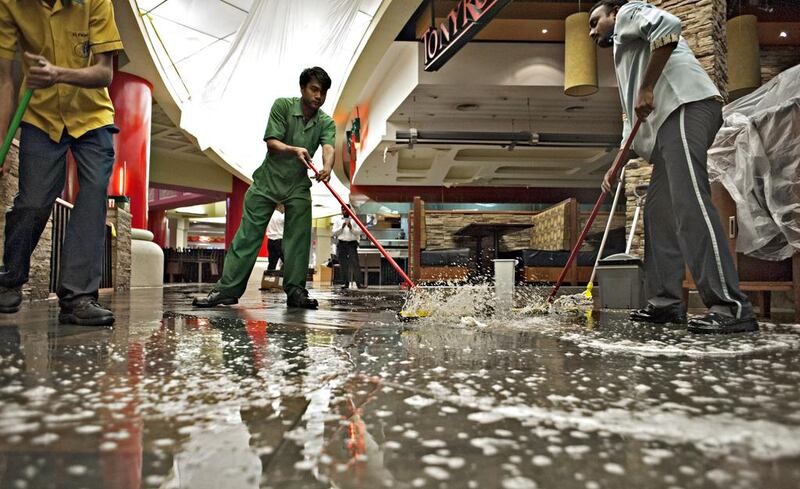 Workers clean up at the Tony Roma’s restaurant after heavy rains caused the roof of Ibn Battuta Mall to leak in several places. Jeff Topping for The National