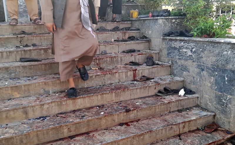 A man walks down the mosque's blood-stained steps following the bombing.