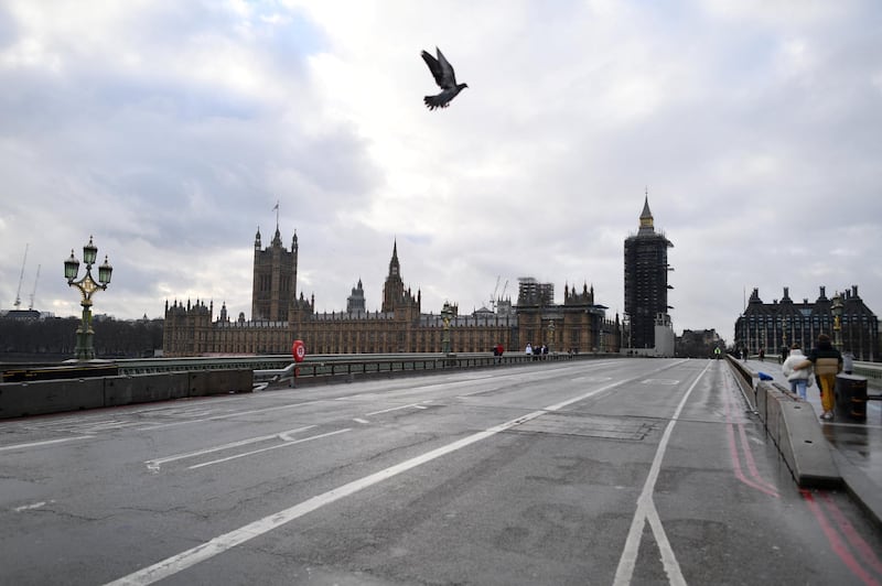 A bird flies over a near-deserted Westminster Bridge in central London on January 16, 2021, during the third nationwide novel coronavirus COVID-19 lockdown. - All arrivals to the UK will have to quarantine and show negative virus tests from next week, British Prime Minister Boris Johnson said Friday, as hospitalisations and deaths continued to soar but new cases fell. (Photo by JUSTIN TALLIS / AFP)