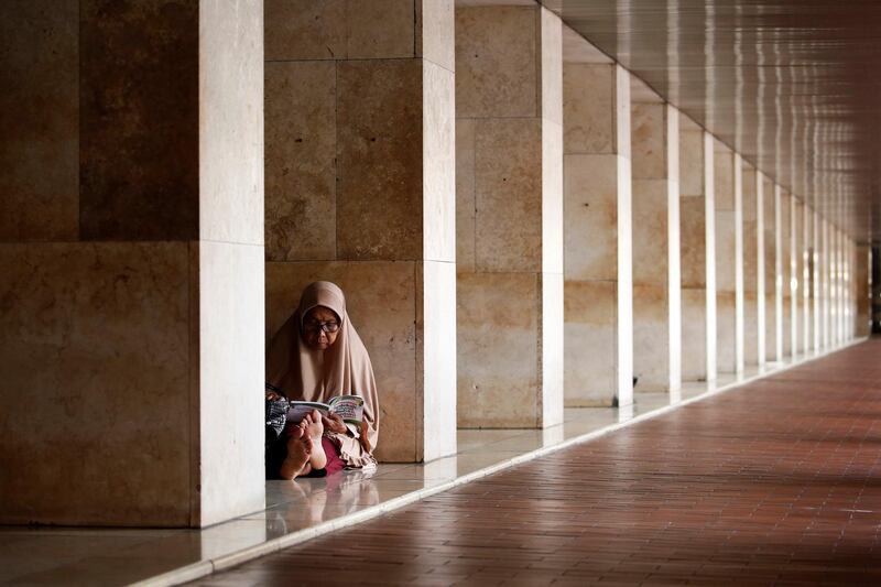 A Muslim woman reads as she waits for iftar at Istiqlal mosque in Jakarta, Indonesia. Beawiharta / Reuters