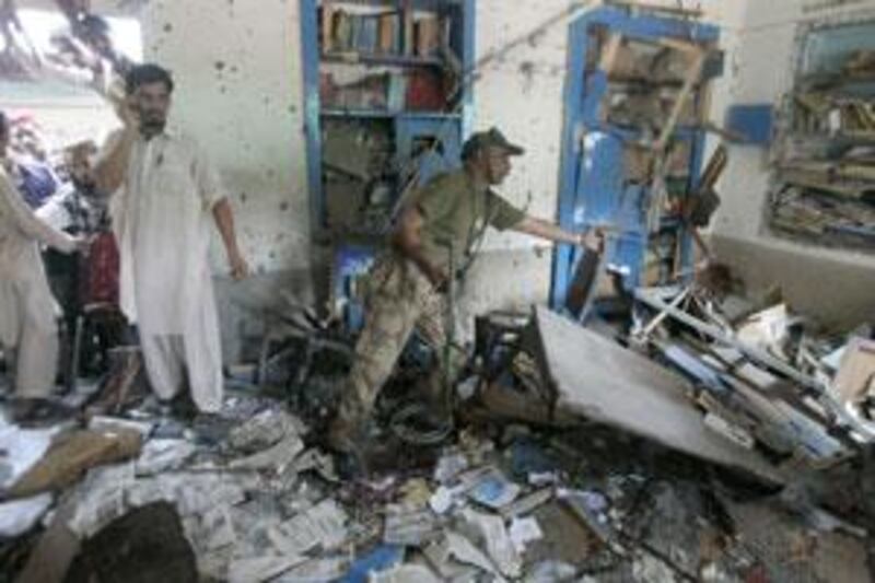 A Pakistani official, centre, checks a room after a suicide attack in Lahore,