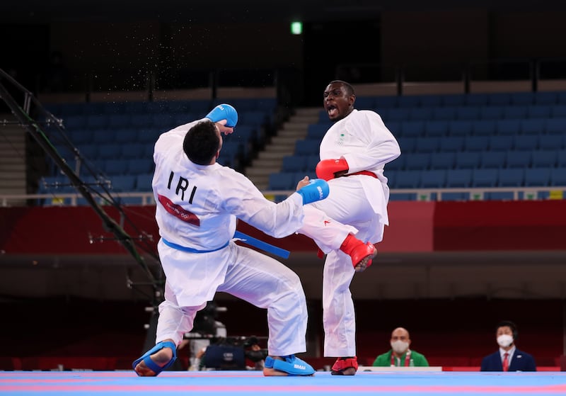 Sajad Ganjzadeh of Iran goes down unconscious after a high-kick from Tareg Hamedi of Saudi Arabia during the Men's Kumite +75kg Gold Medal final.