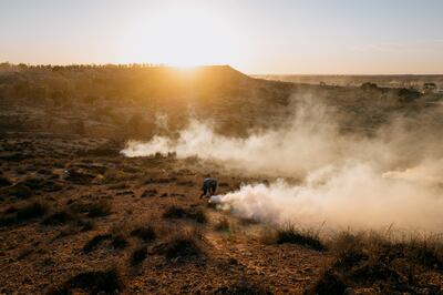 A protester runs from tear gas launched by security forces across from the landfill in Agareb on Wednesday. Photo: Erin Clare Brown / The National