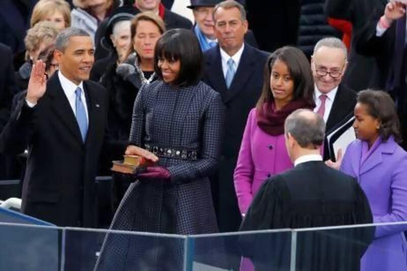 US Supreme Court chief justice John Roberts (back to camera) administers the oath of office to President Barack Obama as first lady Michelle Obama and daughters Malia and Sasha look on.