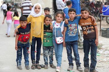 Syrian children pose for a picture at a makeshift playground while celebrating Eid al-Fitr, the Muslim holiday which starts at the conclusion of the holy fasting month of Ramadan, in Ariha in the rebel-held northwestern Syrian province of Idlib on May 26, 2020. / AFP / OMAR HAJ KADOUR