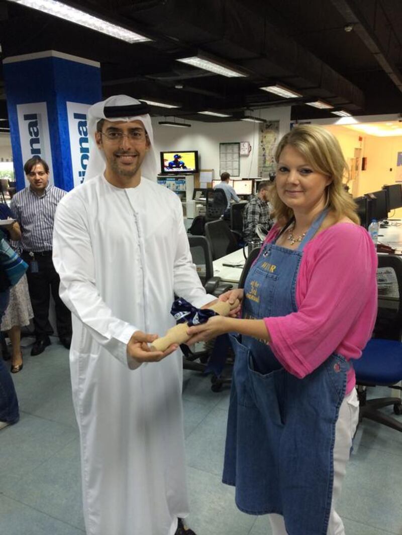 Editor-in-chief, Mohammed Al Otaiba presents winner food writer Stacie Overton Johnson with a rolling pin and apron. 