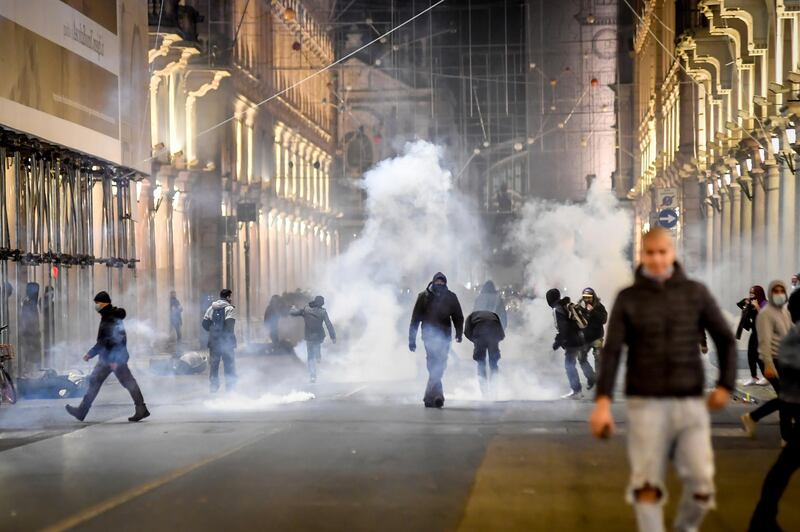 Smoke billows during clashes in Turin. Protesters turned out by the hundreds in several cities and towns on Monday to vent anger. AP Photo