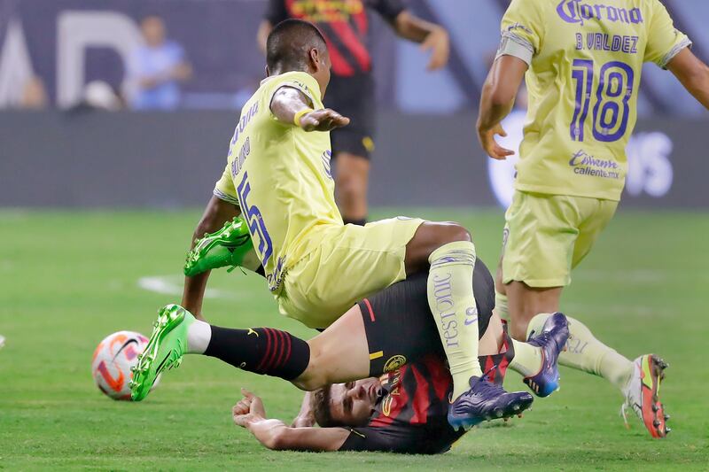 Club América's Pedro Aquino, top, falls onto Manchester City forward Julian Alvarez. AP Photo
