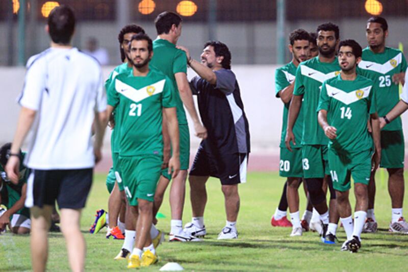 Dubai, United Arab Emirates, Aug. 4 2011, Maradona's Arrival to Al Wasl- (center Black Kit) Diego Maradona head coach of Al Wasl FC embraces his recruited player #19 Juan Manuel Olivera (left center) near midfield on the practice pitch at the Al Wasl FC in Dubai. Maradona arrived the night before Aug. 3 2011 and took control of his team today. Mike Young / The National
