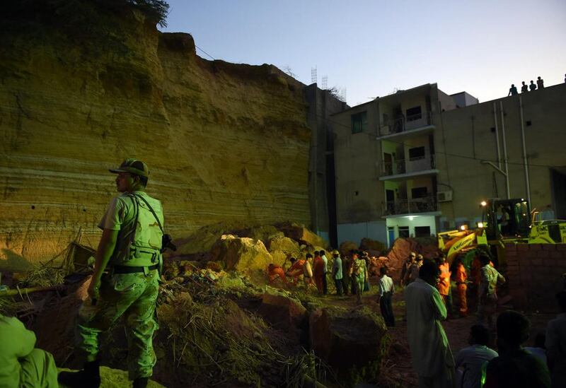 Pakistani paramilitary soldiers and rescuers search for victims in the debris. Asif Hassan / AFP