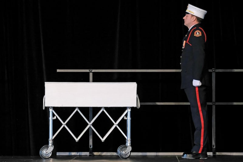 A member of the Halifax Regional Fire Honour Guard stands vigil over the casket of one of the Barho family children. Reuters