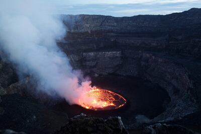 In this March 31, 2010 photo, smoke rises off of churning magma in the lava lake of Mount Nyiragongo, one of Africa's most active volcanos, outside Goma, Congo. Mount Nyiragongo is the ultimate symbol of death in Goma, the lakeside city it shadows and has overrun several times. Yet it's also a symbol of rebirth and resilience for a nation slowly emerging from war. In March, park rangers cleared Rwandan militias from its slopes and reopened the summit for the first time in a year and a half. (AP Photo/Rebecca Blackwell)