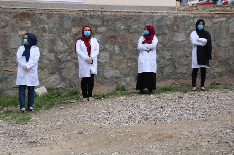 Health officials wait outside, during the disinfection of a hospital for coronavirus patients and suspects, in Herat Afghanistan.  EPA