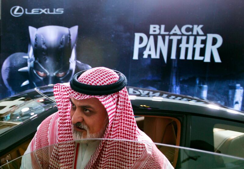 A visitor checks out a Lexus car, similar to a one used in the Black Panther film, that is on display outside an invitation-only screening, at the King Abdullah Financial District Theater, in Riyadh, Saudi Arabia, Wednesday, April 18, 2018. Saudi Arabia held a private screening of the Hollywood blockbuster "Black Panther"  Wednesday, to herald the launch of movie theaters that are set to open to the public next month. (AP Photo/Amr Nabil)